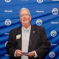 Bob Stoll smiles holding his award